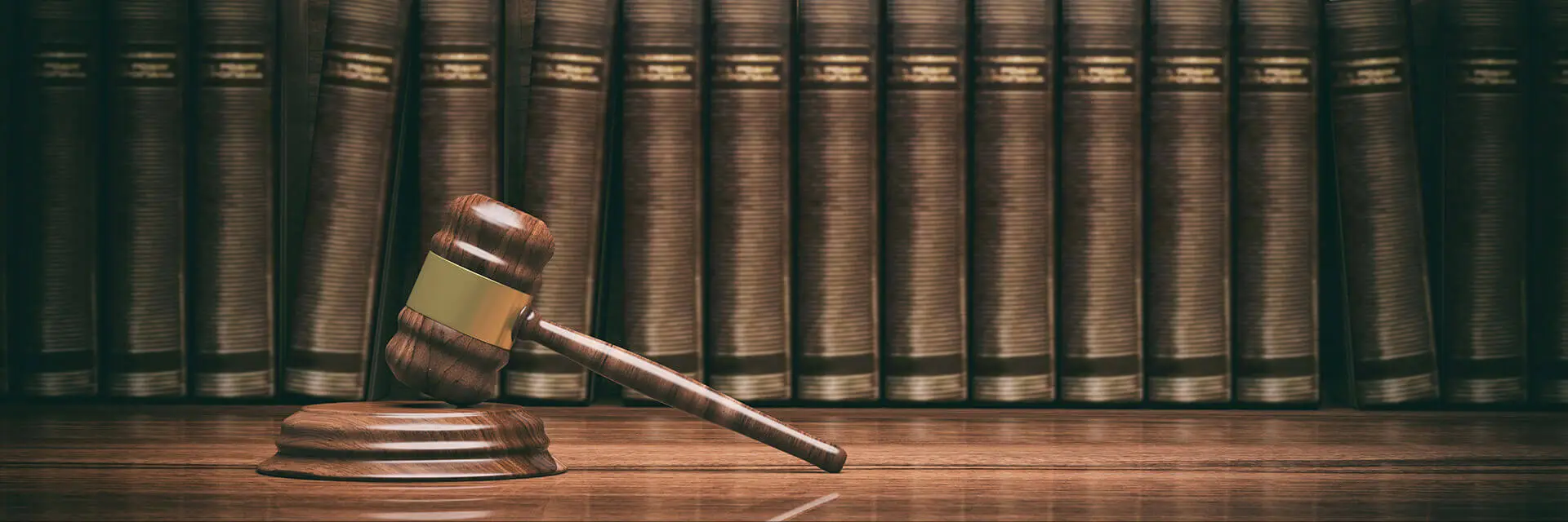 Gavel resting in front of a shelf of law books